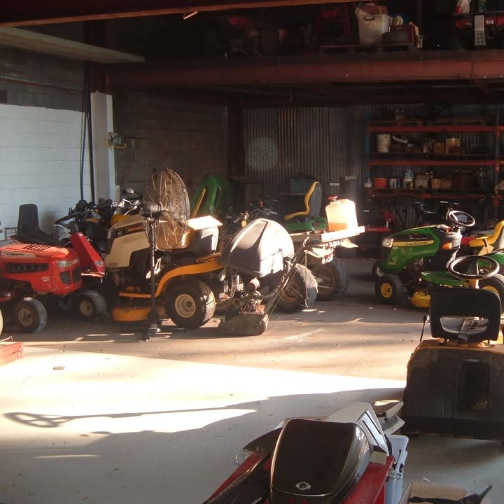 The mower bay, with a row of ride-on mowers parked up waiting for work